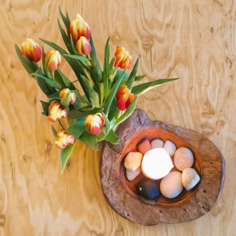 Foto von Tulpenstrauß und Schale mit Licht und Steinen